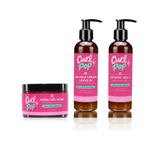 Le Trio Définition Curl Pop — Hydra Curl Mask 250 ml, Bounce Cream Leave-In 200 ml et Crystal Jelly 200 ml sur fond blanc